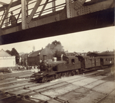 165262 Afbeelding van een trein getrokken door een stoomlocomotief uit de serie 5800 van de N.S. op de spoorwegovergang ...